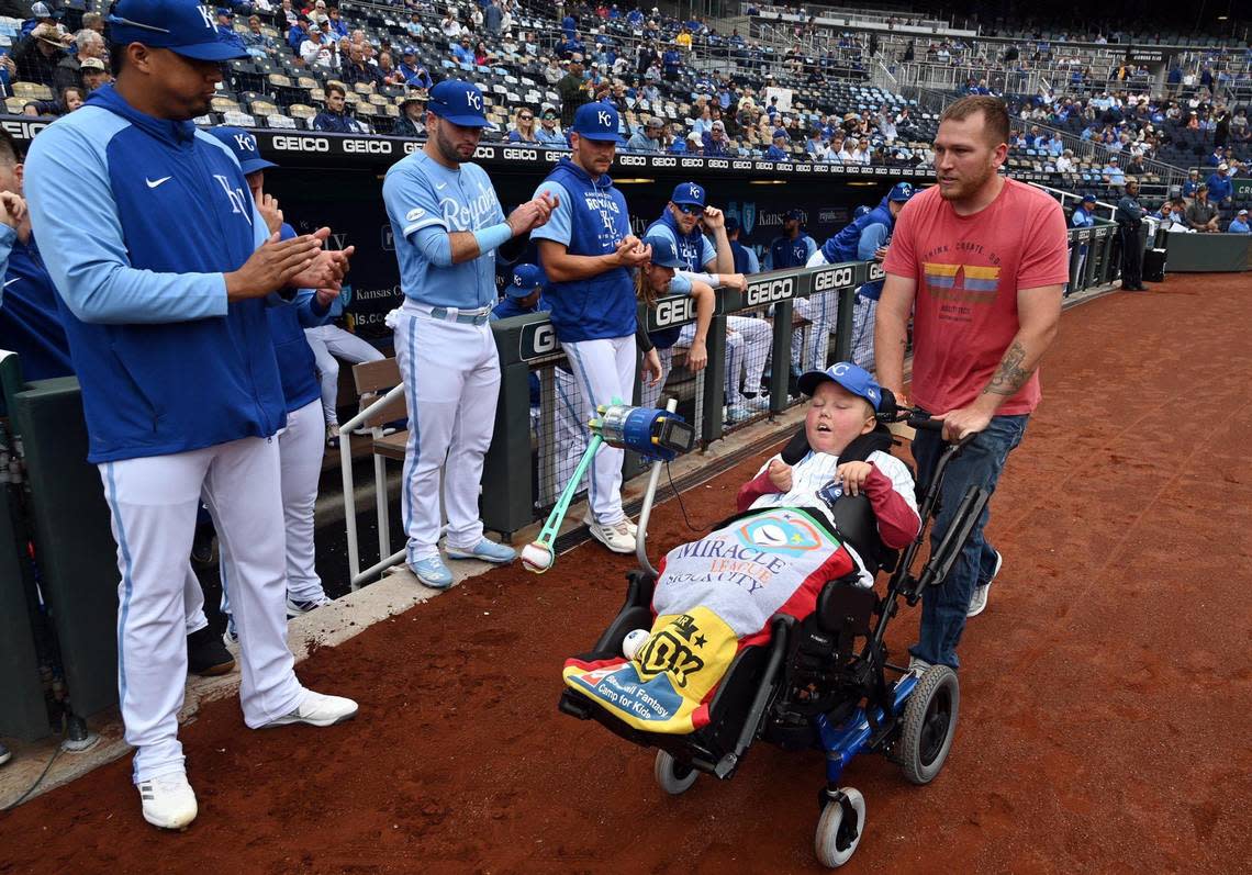 Kayden Rhoades was given 24 hours to live at birth, but 15 years later he threw out the first pitch on Thursday at Kauffman Stadium with the loving help of his family. Rhoades, who was born with hydranencephaly, used a device his father Dustin, above, created for him to complete the feat. Kayden also received a bat from Royals’ second baseman, Nicky Lopez, and a standing ovation from the Royals players. It was a bucket list day in every way for the family from Sioux City, Iowa.