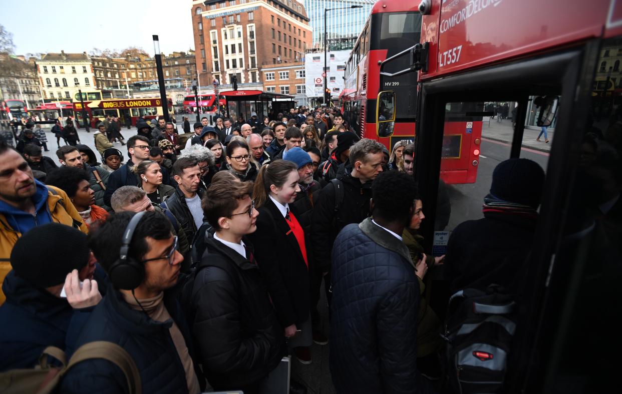 People queue for buses outside Victoria station in London on Wednesday 15 March 2023 (EPA)