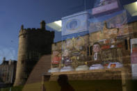 Souvenirs are displayed for sale in the window of a shop with a reflection of Windsor Castle, in Windsor, England, where Prince Andrew residence is nearby in the grounds of Windsor Great Park, Thursday, Jan. 13, 2022. A judge has — for now — refused to dismiss a lawsuit against Britain's Prince Andrew by an American woman who says he sexually abused her when she was 17. Stressing Wednesday that he wasn't ruling on the truth of the allegations, U.S. District Judge Lewis A. Kaplan rejected an argument by Andrew's lawyers that Virginia Giuffre's lawsuit should be thrown out at an early stage because of an old legal settlement she had with Jeffrey Epstein, the financier she claims set up sexual encounters with the prince. (AP Photo/Matt Dunham)