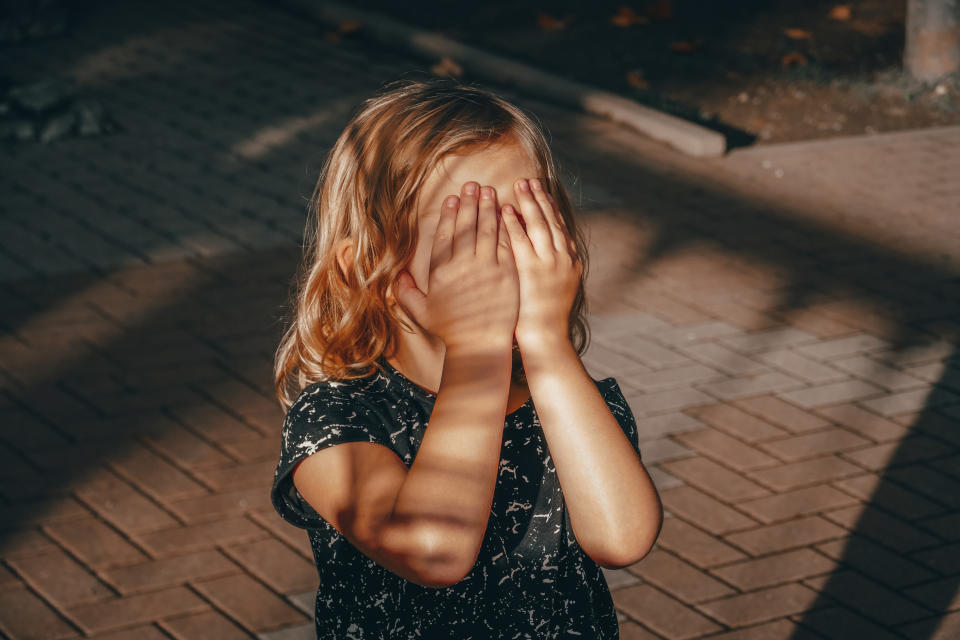 a child with hands over its face