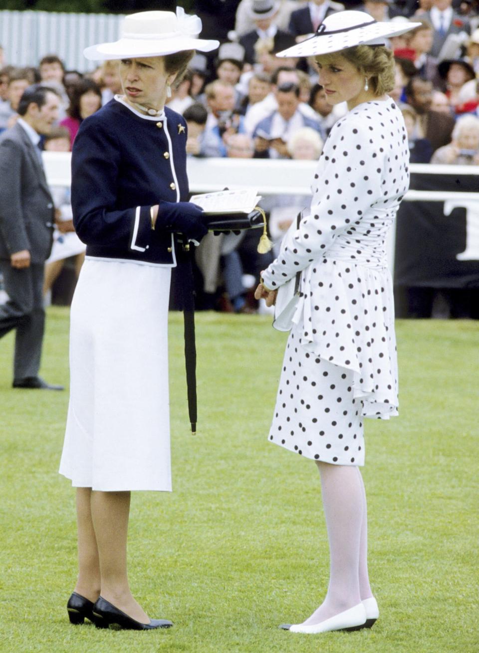 Diana Princess of Wales (R), wearing a dress by Victor Edelstein and hat by Frederick Fox and Princess Anne, Princess Royal (L) attend the Epsom Derby on June 04, 1986 in Surrey, United Kingdom