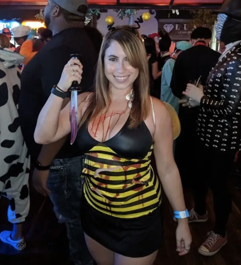 Someone dressed as a bloody bee while holding a knife