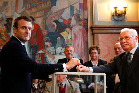 French presidential election candidate Emmanuel Macron, head of the political movement En Marche !, or Onwards !, casts his ballot to vote in the second round of 2017 French presidential election, at a polling station in Le Touquet, France, May 7, 2017. REUTERS/Christophe Ena/Pool