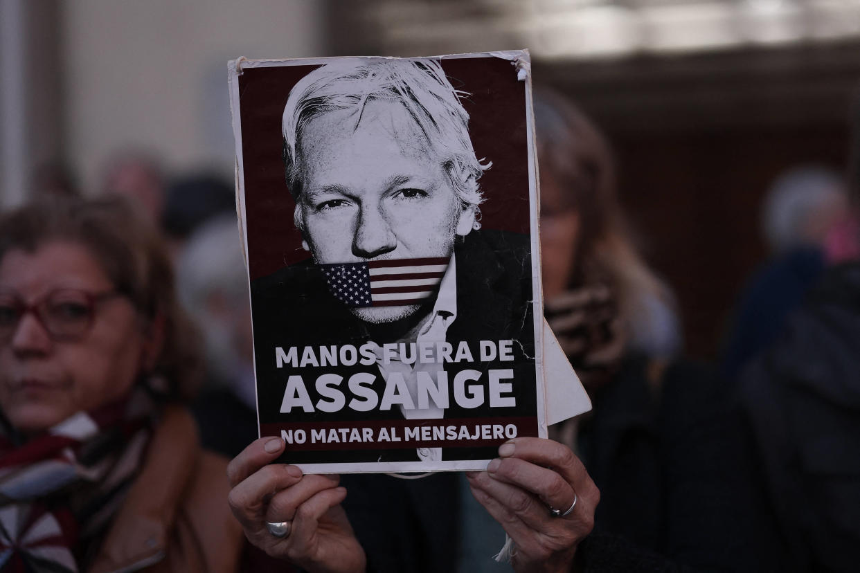 Un manifestant tenant une pancarte avec le visage de Julian Assange, et le message « Pas touche à Assange, ne tuez pas le messager », lors d’une manifestation à Madrid le 20 février 2024 