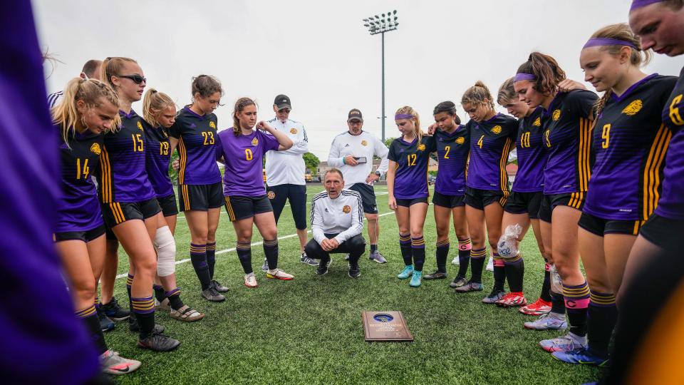New Berlin Eisenhower girls soccer coach Nick Datka, center kneeling, congratulates his team on its WIAA Division 3 sectional championship after a 2-1 victory over Shorewood in 2022.