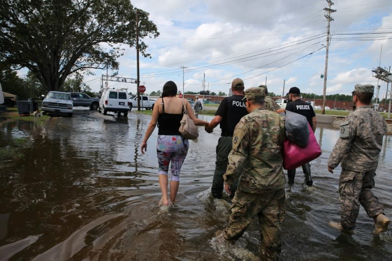 Members of police and North Carolina National Guard assist a pregnant woman in Lumberton, North Carolina