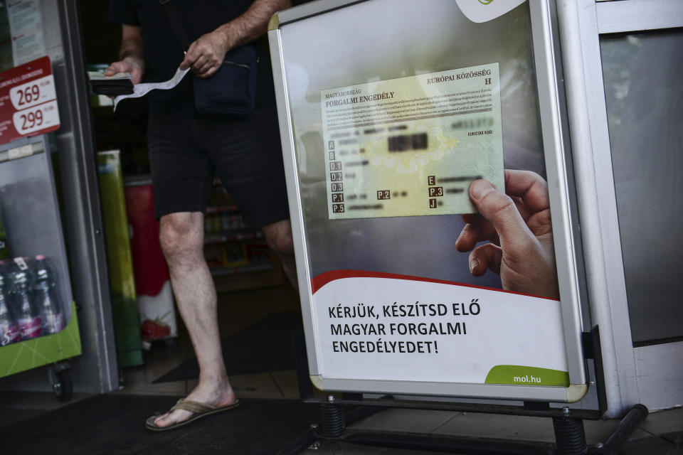 Writing on an information board at a petrol station reads "Please prepare your Hungarian registration certificate" that allows Hungarian drivers to buy fuel at a discounted price, in Budapest, Hungary, Sunday, June 12, 2022. Hungary has placed price caps on fuel and some food and imposed special taxes on industries as the government tries to ease an economic downturn and the highest inflation in nearly 25 years. (AP Photo/Anna Szilagyi)