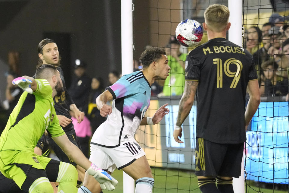 Minnesota United midfielder Hassani Dotson, second from right, scores on a header as Los Angeles FC midfielder Mateusz Bogusz, right, watches along with goalkeeper Maxime Crépeau, left, during the first half of a Major League Soccer match Wednesday, Oct. 4, 2023, in Los Angeles. (AP Photo/Mark J. Terrill)