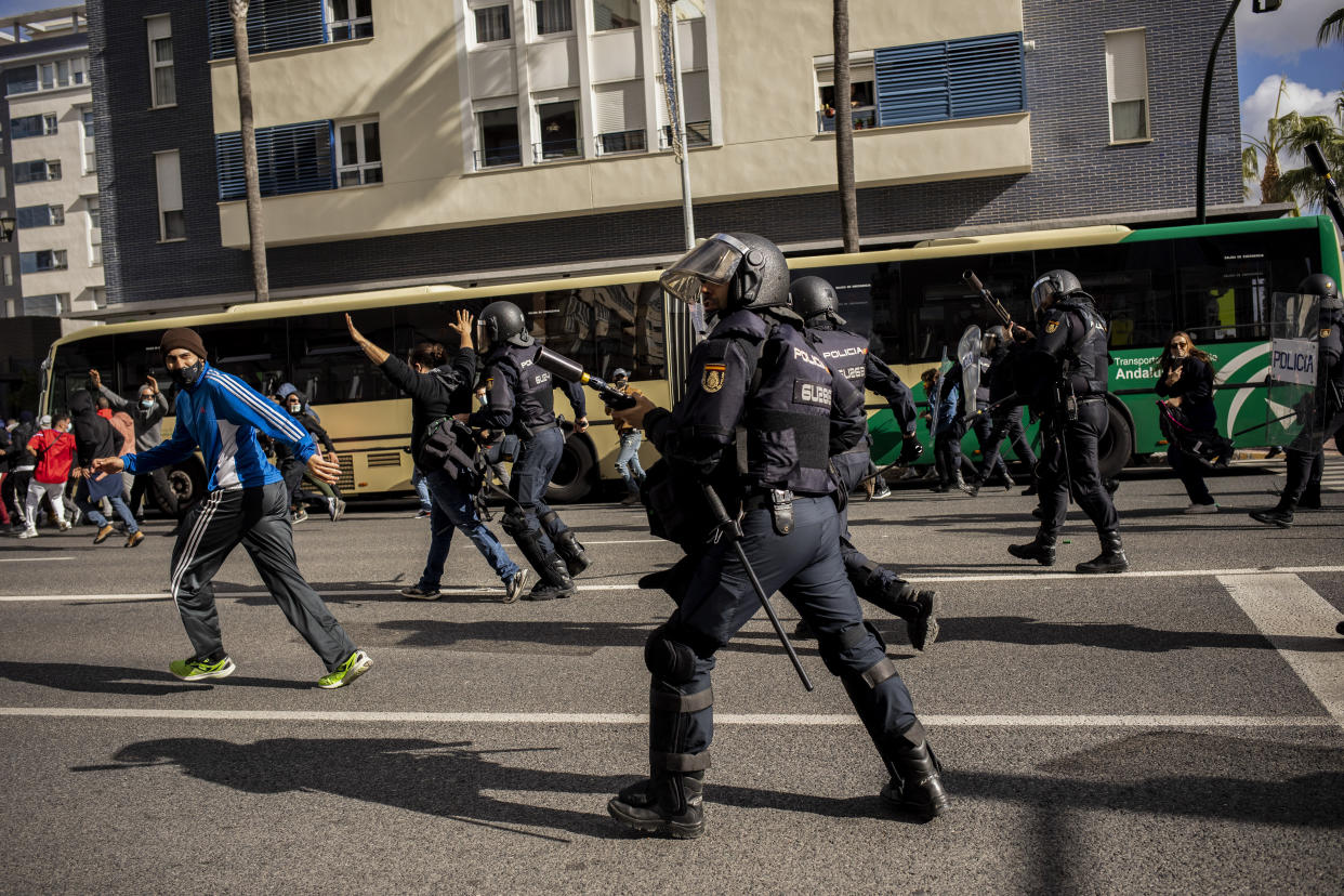 Anti-riot police, right, and protesters clash during a strike organized by metal workers in Cadiz, southern Spain, Tuesday, Nov. 23, 2021. (AP Photo/Javier Fergo)