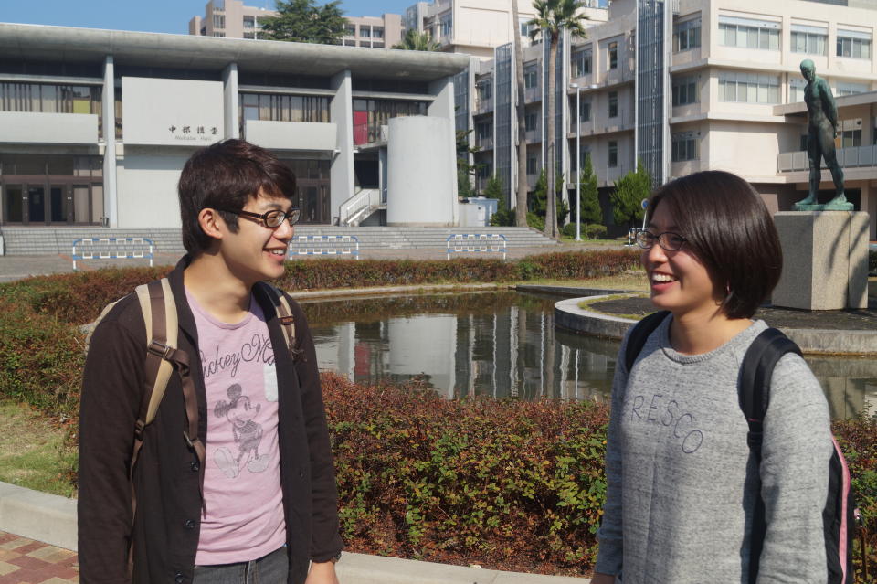 <p>Hanako Misuoka and Jo Takeda, both 21, talk near the fountain at Nagasaki University. (Photo: Michael Walsh/Yahoo News) </p>