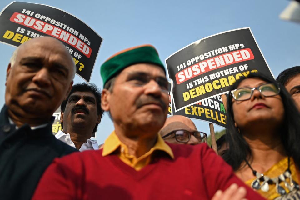 Τα μέλη του κοινοβουλίου κρατούν πλακάτ καθώς συμμετέχουν σε πορεία διαμαρτυρίας στο Νέο Δελχί στις 21 Δεκεμβρίου 2023 ενάντια στην παύση των βουλευτών που ανήκουν σε μια ομάδα 26 κομμάτων της αντιπολίτευσης που ονομάζεται ΙΝΔΙΑ (AFP μέσω Getty Images)