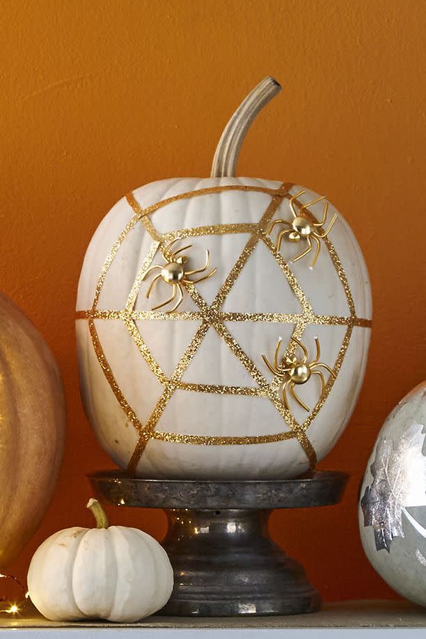 <p>Spray paint your pumpkin white and let dry, then hot-glue three long strips of ¼-inch glittered ribbon to to create radial threads of web. Measure, cut, and glue 12 shorter ribbon strips to complete the web. Spray paint several fake spiders gold, then hot-glue to your "web."</p><p><a class="link " href="https://www.amazon.com/Muzboo-Realistic-Plastic-Halloween-Decorations/dp/B07CVJ3LBN?tag=syn-yahoo-20&ascsubtag=%5Bartid%7C10070.g.1902%5Bsrc%7Cyahoo-us" rel="nofollow noopener" target="_blank" data-ylk="slk:Shop Fake Spiders">Shop Fake Spiders</a> </p>