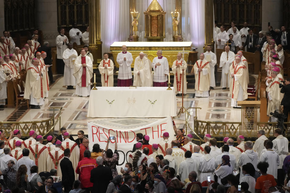 People display a banner during the Pope Francis mass at the National Shrine of Saint Anne de Beaupré in Quebec City, Canada, Thursday, July 28, 2022. Pope Francis crisscrossed Canada this week delivering long overdue apologies to the country's Indigenous groups for the decades of abuses and cultural destruction they suffered at Catholic Church-run residential schools. (AP Photo/Gregorio Borgia)