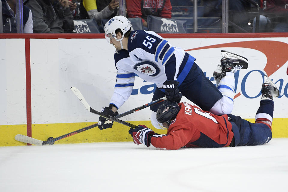 Winnipeg Jets center Mark Scheifele (55) battles for the puck against Washington Capitals defenseman Michal Kempny (6), of the Czech Republic, during the second period of an NHL hockey game, Sunday, March 10, 2019, in Washington. (AP Photo/Nick Wass)