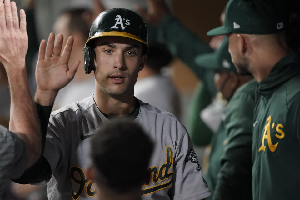 Oakland Athletics' Matt Olson is greeted in the dugout after he scored during the seventh inning of the team's baseball game against the Seattle Mariners, Tuesday, June 1, 2021, in Seattle. (AP Photo/Ted S. Warren)