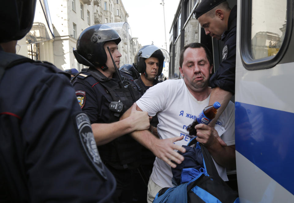 Police officers detain a man prior to an unsanctioned rally in the center of Moscow, Russia, Saturday, July 27, 2019. OVD-Info, an organization that monitors political arrests, said about 50 people had been detained by 1:30 p.m. Saturday (1030 GMT), a half-hour before the protest against the exclusion of opposition figures from the ballot for city council elections was to start. (AP Photo/Alexander Zemlianichenko)