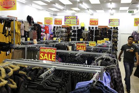 A shopper walks past sale signs at a shopping centre in Lenasia, south of Johannesburg, August 28, 2013. When Wal-Mart Stores, the world's top retailer, bought control of major South African discount chain Massmart Holdings in 2011, American shopping mall developer Irwin Barkan had an epiphany. An industry veteran of 30 years, Barkan's U.S. home market was "greying", while the youthful, underdeveloped African continent offered a sweet spot, with a rapidly expanding middle class and no competition from online retailers. Picture taken August 28, 2013. REUTERS/Siphiwe Sibeko