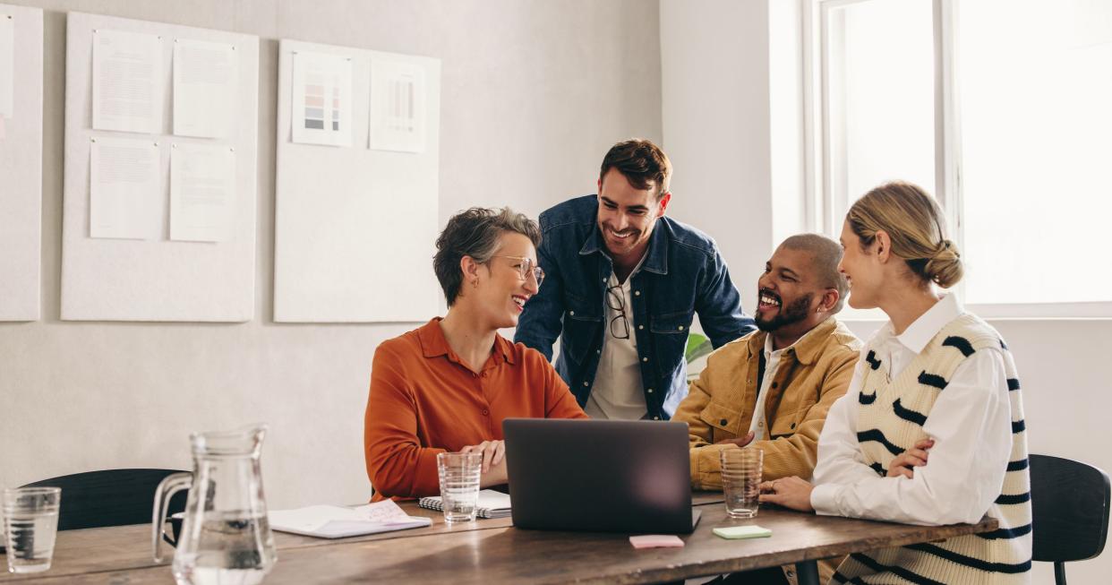 Cheerful designers smiling happily while having a meeting in an office. Group of successful businesspeople working on a new interior design project in a creative workplace.