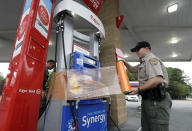 New Hanover Sheriff's Corp. N. Brothers wraps a gas pump for protection in Wilmington, N.C., as Hurricane Florence threatens the coast Thursday, Sept. 13, 2018. (AP Photo/Chuck Burton)