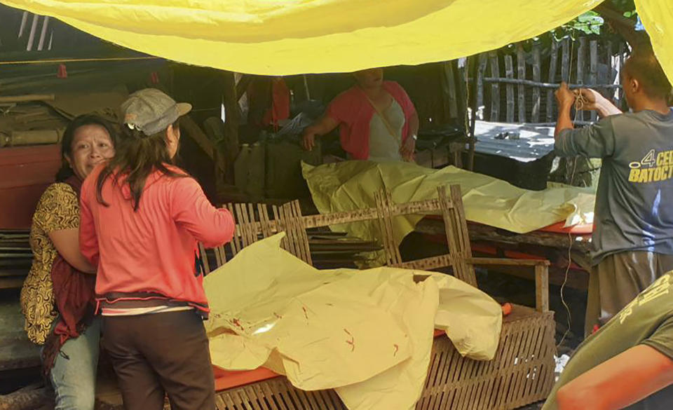 Relatives grieve as they sit beside bodies of victims from a deadly road accident at Boljoon town, Cebu province, central Philippines on Friday July 19, 2019. A truck carrying more than two dozen villagers, mostly ecstatic grade schoolers on their way to a school festival, lost control Friday on a downhill road and flipped on its side, leaving several students and an adult companion dead in the central Philippines, police said. (AP Photo)