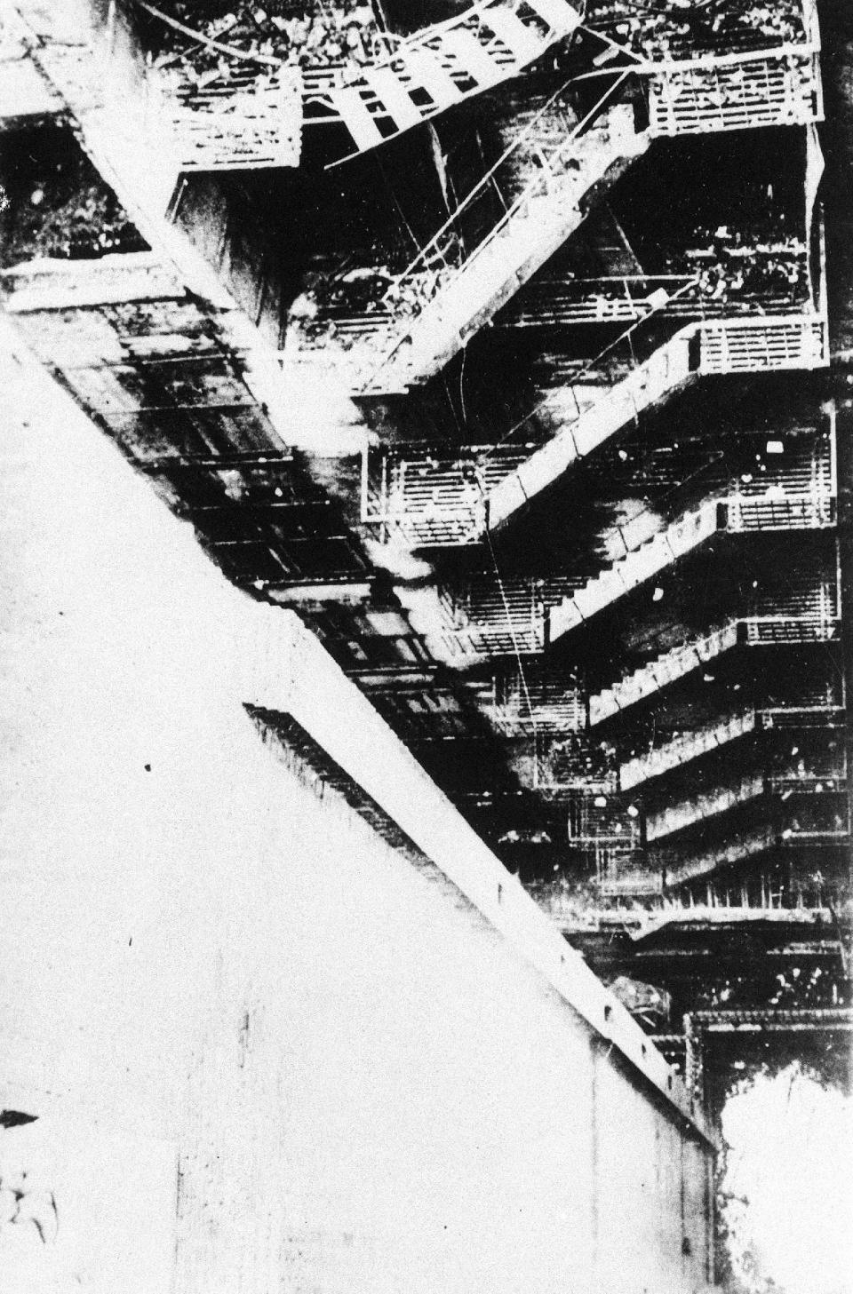 FILE - This is a 1911 file photo of the collapsed remains of the fire escape of the Triangle Shirt Waist Company in New York City. One hundred years ago, horrified onlookers watched as workers leapt to their deaths from the raging fire in the garment factory. The fire killed 146 workers, mainly young immigrant women and girls, and became a touchstone for the organized labor movement, spurred fire-safety laws and shed light on the lives of immigrant workers. (AP Photo/File)