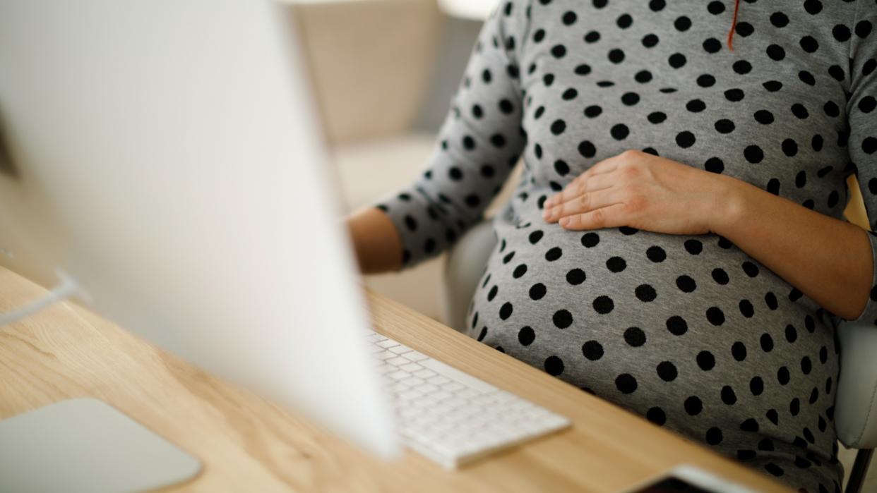 Pregnant woman working from home office.