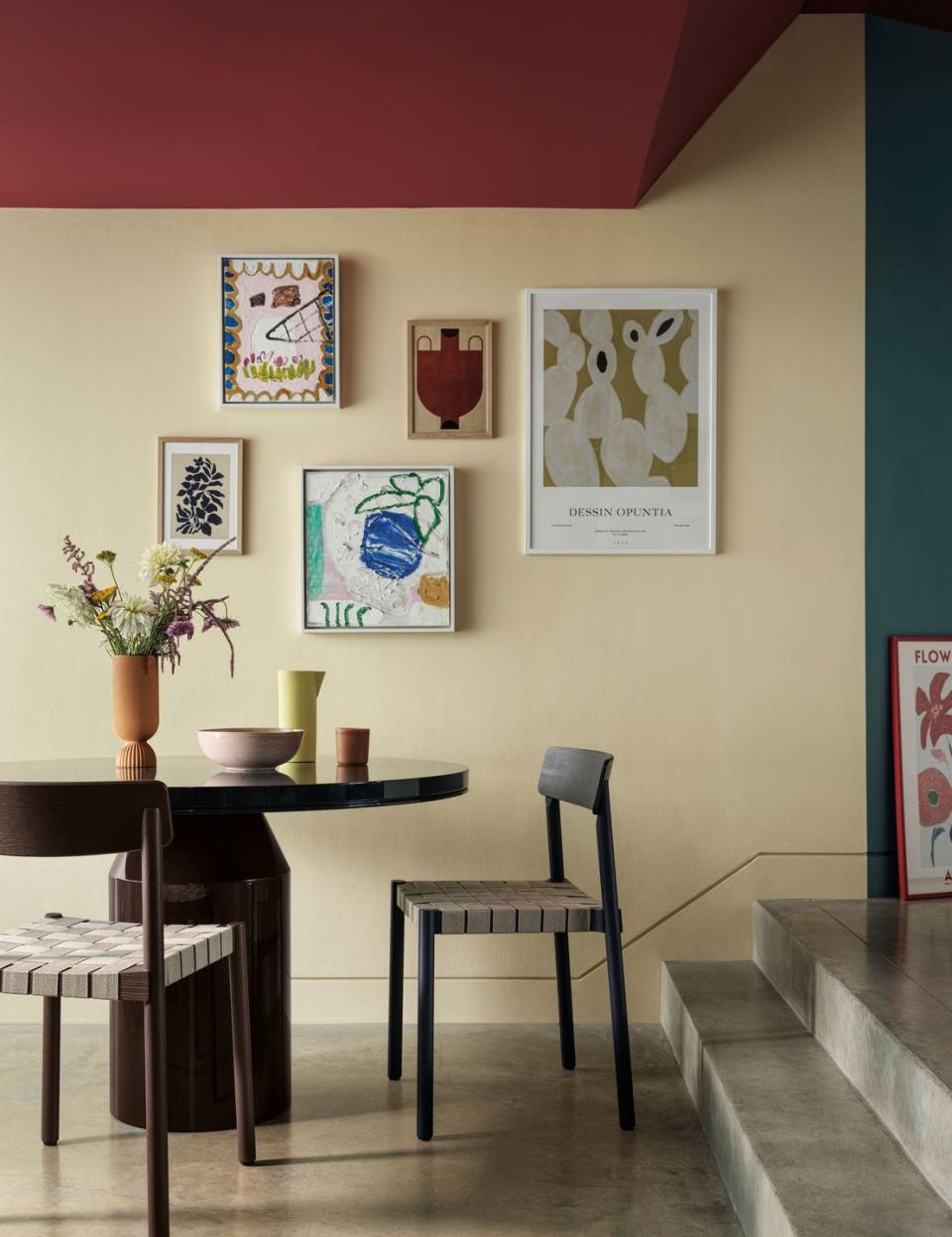 a room with a table chairs and a vase with flowers on it