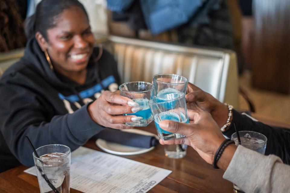 Amber Ogden, Kim Ogden & Kyle Ogden cheers a special game day 'Honolulu blue' cocktail shot at the start of the Detroit Lions game inside Central Kitchen & Bar on Sunday, Jan 21, 2024 in Detroit.