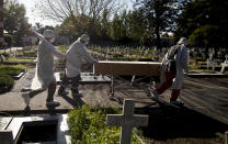 Cemetery workers push the coffin of a COVID-19 victim at a cemetery in Buenos Aires, Argentina, Saturday, May 8, 2021. Argentina has so far reported more than 67,300 confirmed deaths and more than 3.1 million people sickened by the disease. (AP Photo/Natacha Pisarenko)