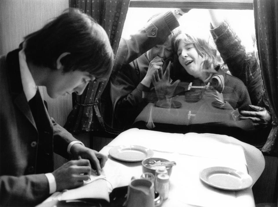 UNSPECIFIED - JANUARY 01:  Photo of BEATLES and George HARRISON; George Harrison on a train during the filming of a 'Hard Day's Night', with adoring fans outside looking through the window -  (Photo by Max Scheler - K & K/Redferns)