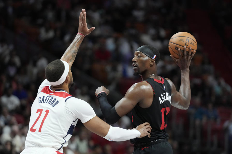 Miami Heat center Bam Adebayo, right, looks for an open teammate past Washington Wizards center Daniel Gafford (21) during the first half of an NBA basketball game, Friday, Nov. 3, 2023, in Miami. (AP Photo/Wilfredo Lee)