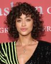 <p>Stop pairing your ringlet curls with a blown-out fringe. Instead, let your bangs take on an equally textured curl pattern and wear them low on the forehead, like model Alanna Arrington.</p>
