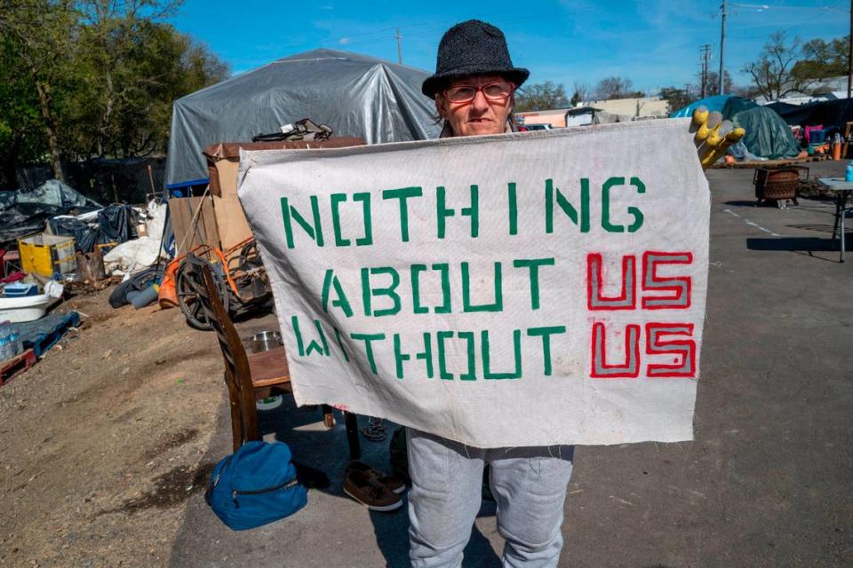 Joyce Williams proudly shows off a sign on Friday representing the solidarity of the residents of Camp Resolution, a self-governing homeless encampment in North Sacramento. She and her partner Sharon Jones, along with other residents, have rallied together to take care of Holly Porter.