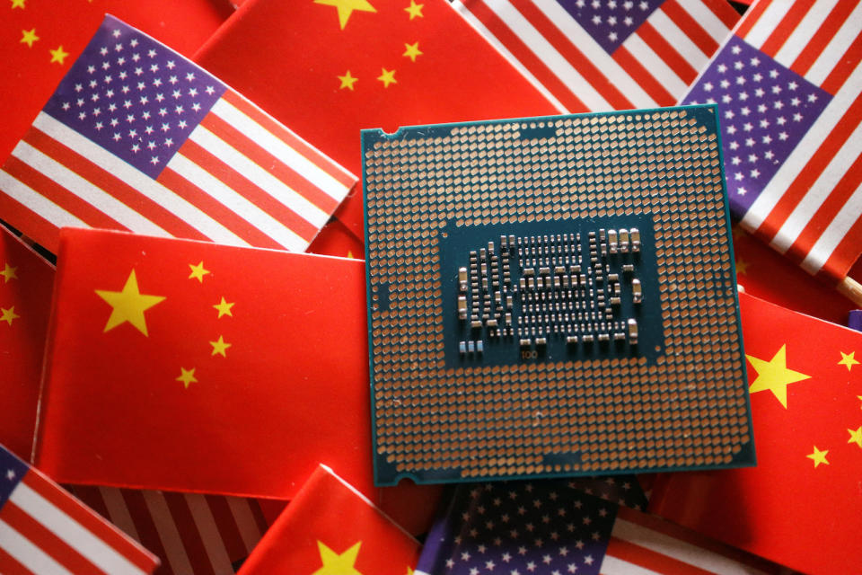 A central processing unit (CPU) semiconductor chip is displayed among flags of China and U.S., in this illustration picture taken February 17, 2023. REUTERS/Florence Lo/Illustration