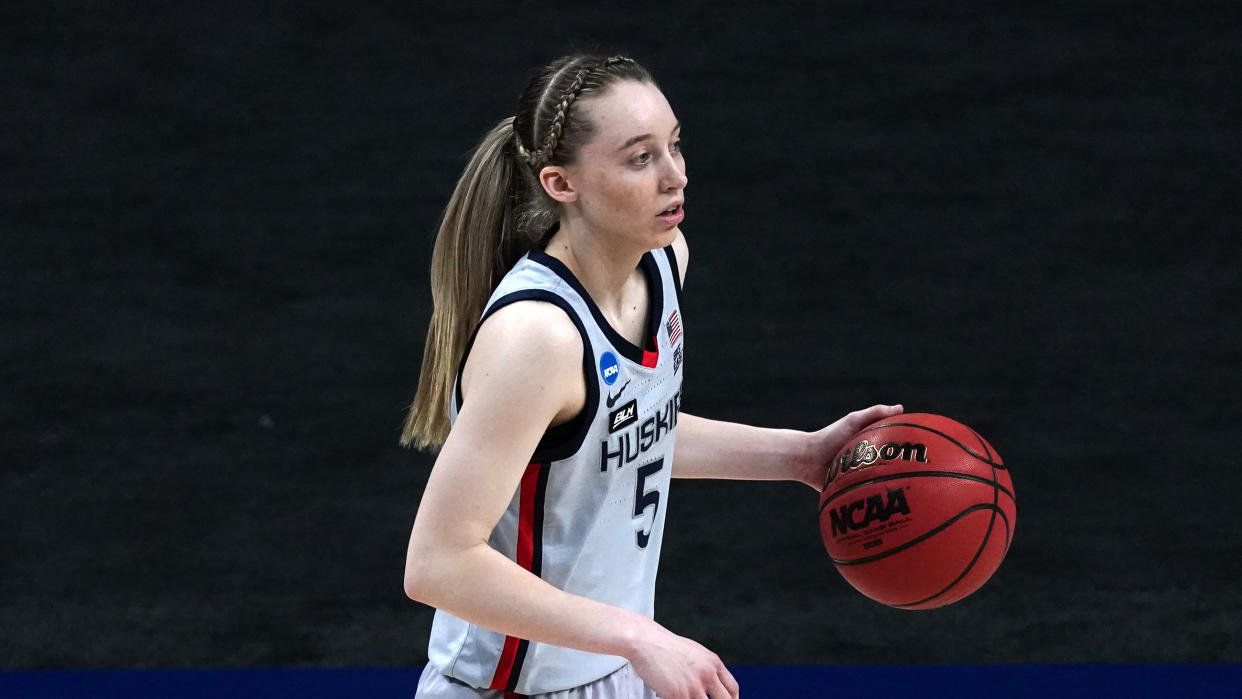 Paige Bueckers with the ball in one hand dribbling.