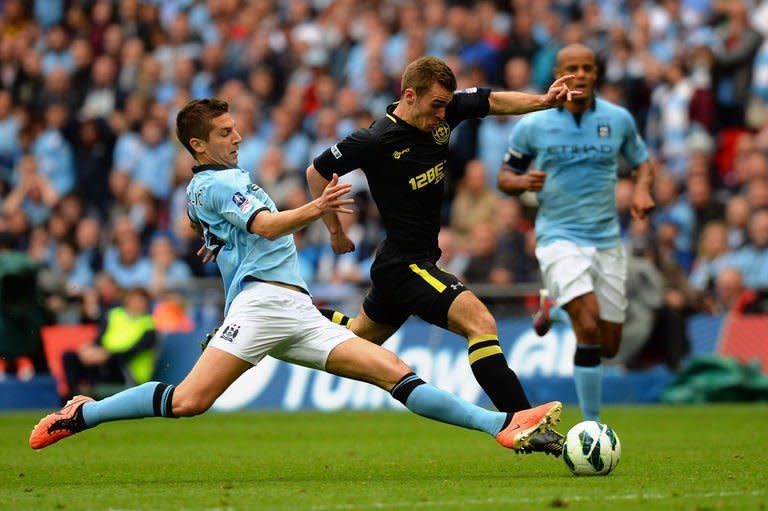 Wigan Athletic's striker Callum McManaman (R) dribbles the ball through the stretching challenge of Manchester City's defender Matija Nastasic during the English FA Cup final at Wembley Stadium in London on May 11, 2013. Wigan won 1-0