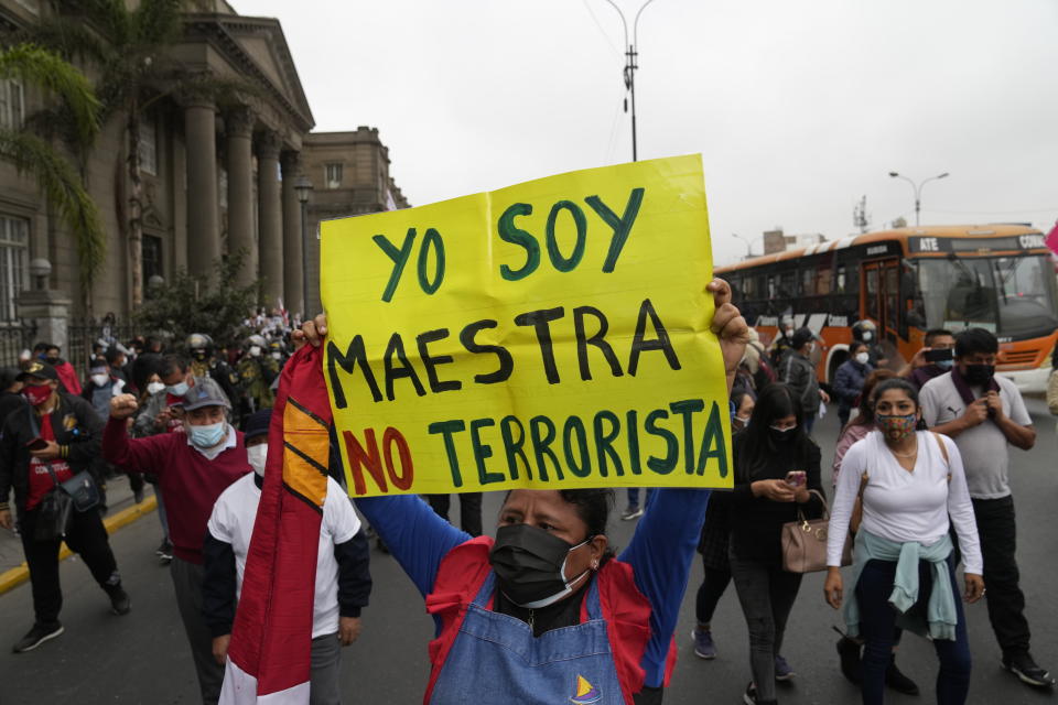 FILE - A woman holds up a sign with a message that reads in Spanish; "I am a teacher, not a terrorist" in a march in support of presidential candidate Pedro Castillo, weeks after the presidential runoff election, in Lima, Peru, June 19, 2021. Castillo defeated by just 44,000 votes one of the most recognizable names among Peru’s political class: Keiko Fujimori, the daughter of former strongman Alberto Fujimori, who is serving a 25-year prison sentence for the murder of Peruvians executed during his government by a clandestine military squad. Keiko Fujimori's supporters have often called Castillo “terruco,” or terrorist, a term often used by the right to attack the left, poor and rural residents. (AP Photo/Martin Mejia, File)