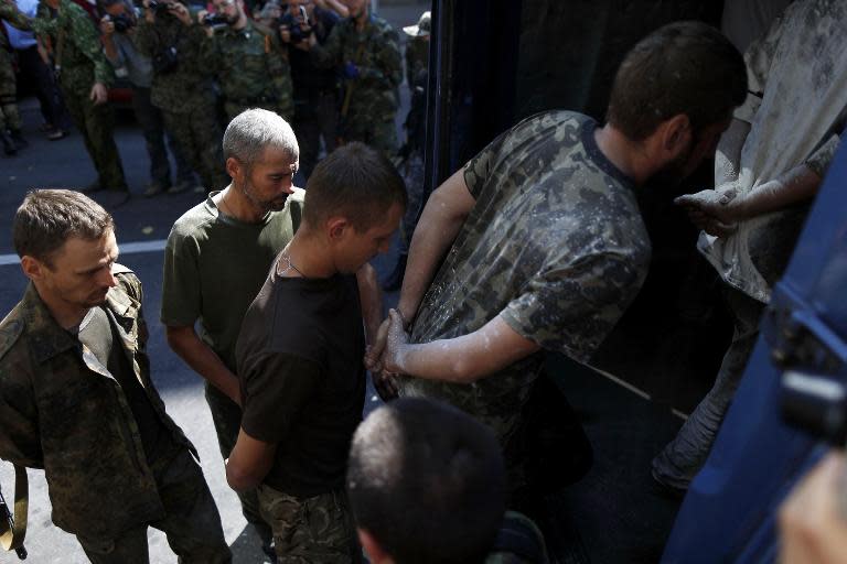 Captured Ukrainian soldiers board a vehicle on August 24, 2014 in Donetsk, eastern Ukraine, during a parade in mockery of the country's Independence Day celebrations