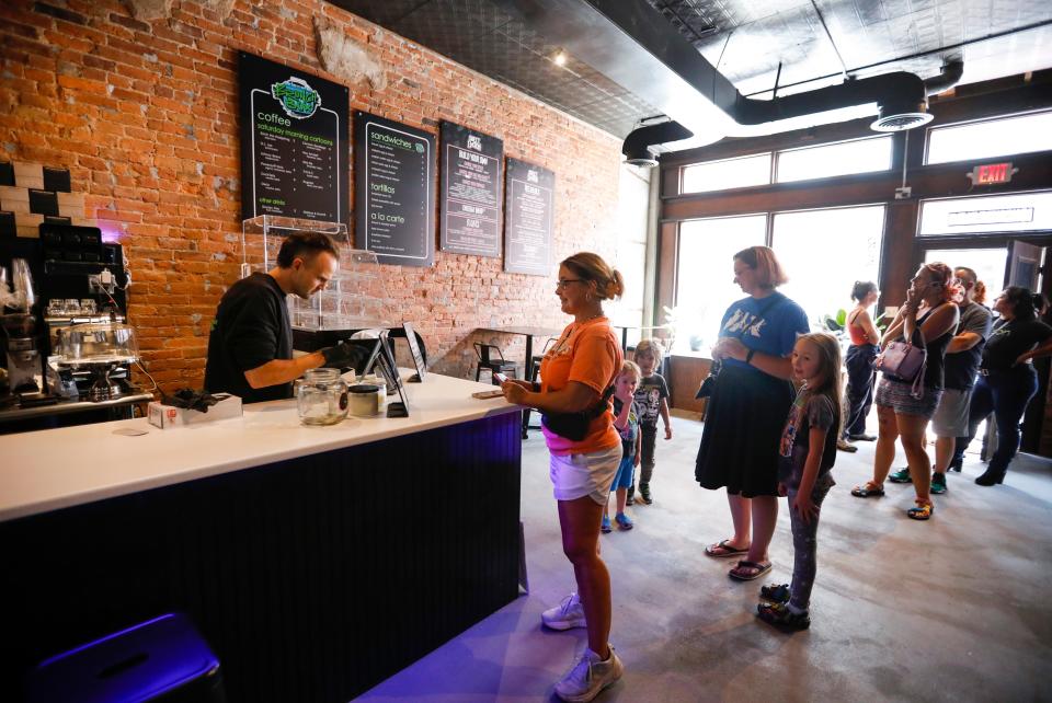 The first customers wait in line at Sweet EMOtion for their grand reopening in a new location downtown on Friday, July 7, 2023. 