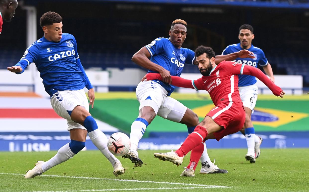 Liverpool's Mohamed Salah (red jersey) in action with Everton's Ben Godfrey and Yerry Mina.
