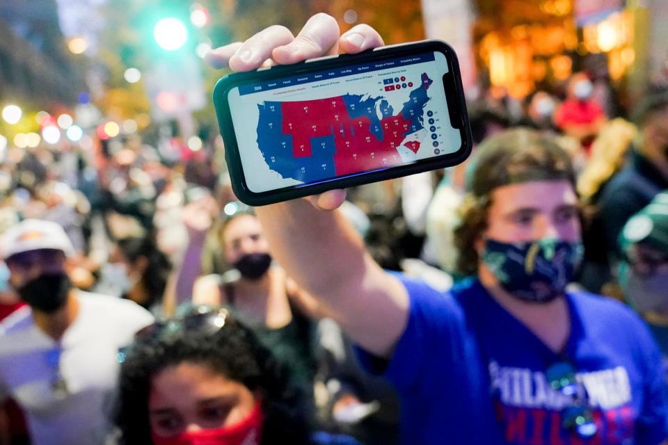 A supporter of President-elect Joe Biden holds up his mobile phone to display the electoral college map outside the Philadelphia Convention Center after the 2020 Presidential Election is called, Saturday, Nov. 7, 2020, in Philadelphia. (AP Photo/John Minchillo) ORG XMIT: PAJL127