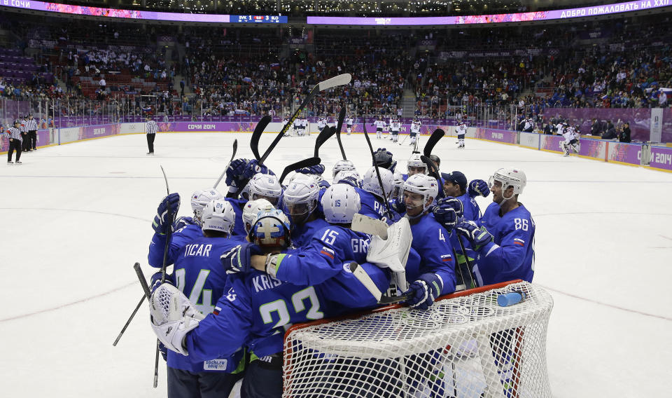 Team Slovenia celebrates a 3-1 win over Slovakia in a men's ice hockey game at the 2014 Winter Olympics, Saturday, Feb. 15, 2014, in Sochi, Russia. (AP Photo/Mark Humphrey )