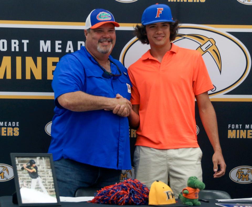 Fort Meade's Carson Montsdeoca shakes hands with his father after signing with Florida on Tuesday.