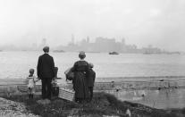 <p>Immigrant family on the dock at Ellis Island, N.Y., looking toward the New York skyline. (Photo: Bettmann Archive via Getty Images) </p>