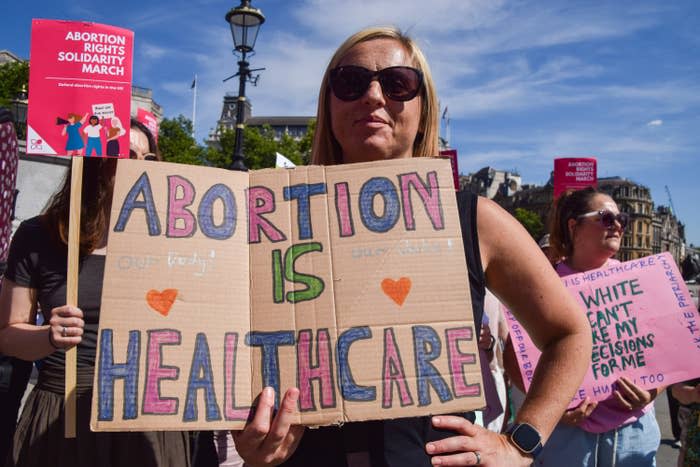 A woman at a protest holding a sign that says "abortion is healthcare"