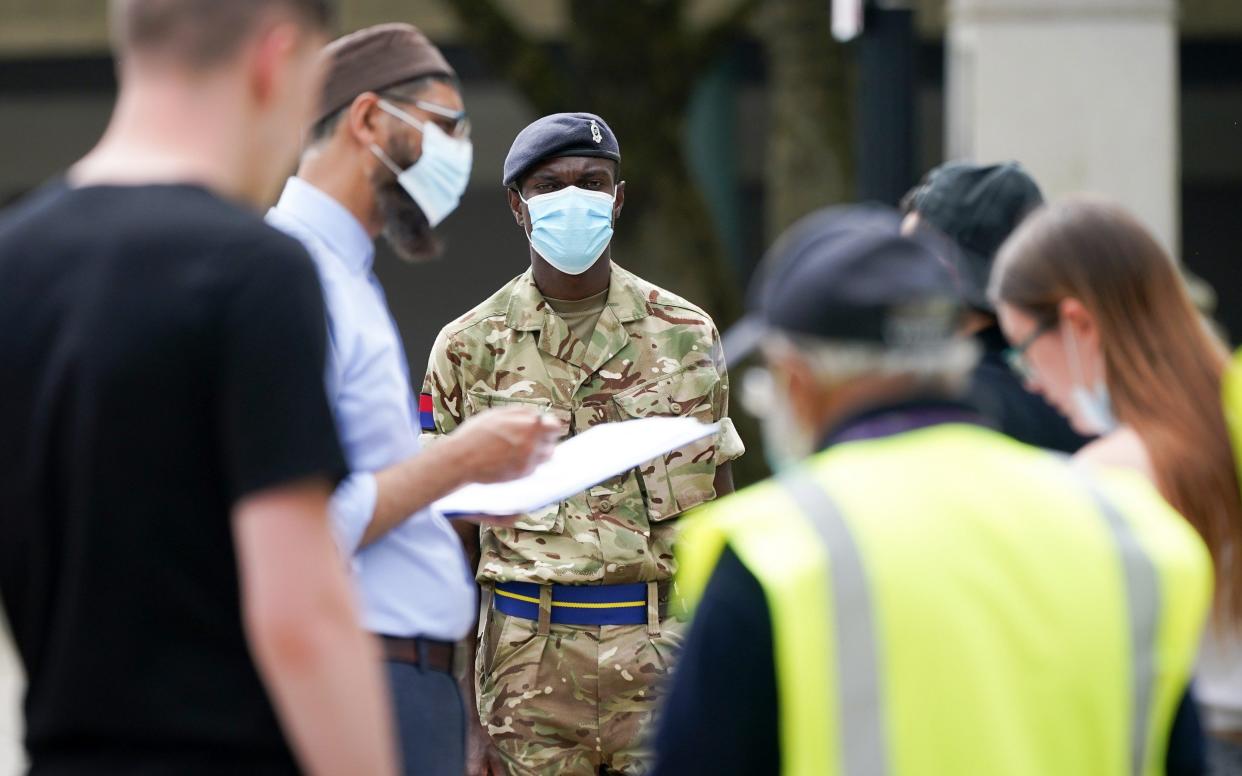 Soldiers from the Royal Horse Artillery guide members of the public at a rapid vaccination centre, set up outside Bolton Town Hall - Getty