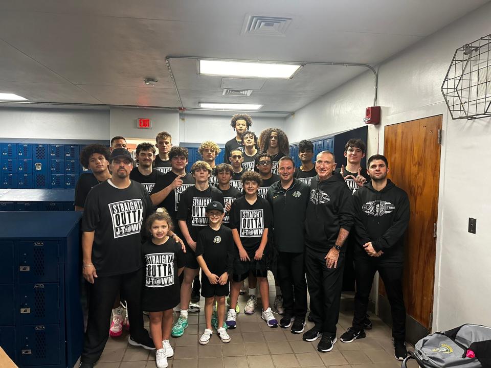 The Jupiter boys basketball team poses together for a celebratory photo in the locker rooms of Dwyer High School after defeating the defending 6A state champions, 49-48, on Friday, January 20, 2024.