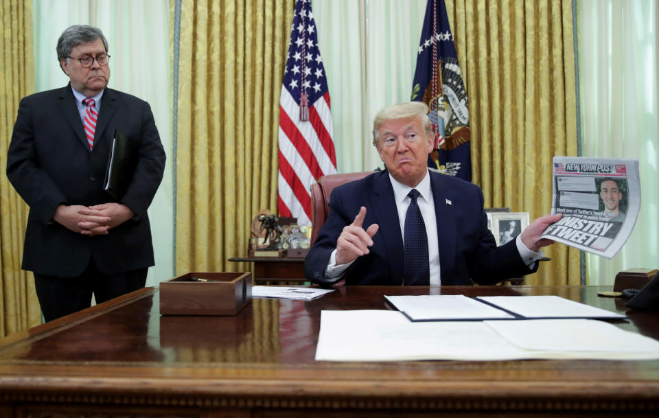 U.S. President Donald Trump speaks to reporters about an executive order regarding social media companies as Attorney General Bill Barr listens in the Oval Office of the White House in Washington, U.S., May 28, 2020. REUTERS/Jonathan Ernst     TPX IMAGES OF THE DAY