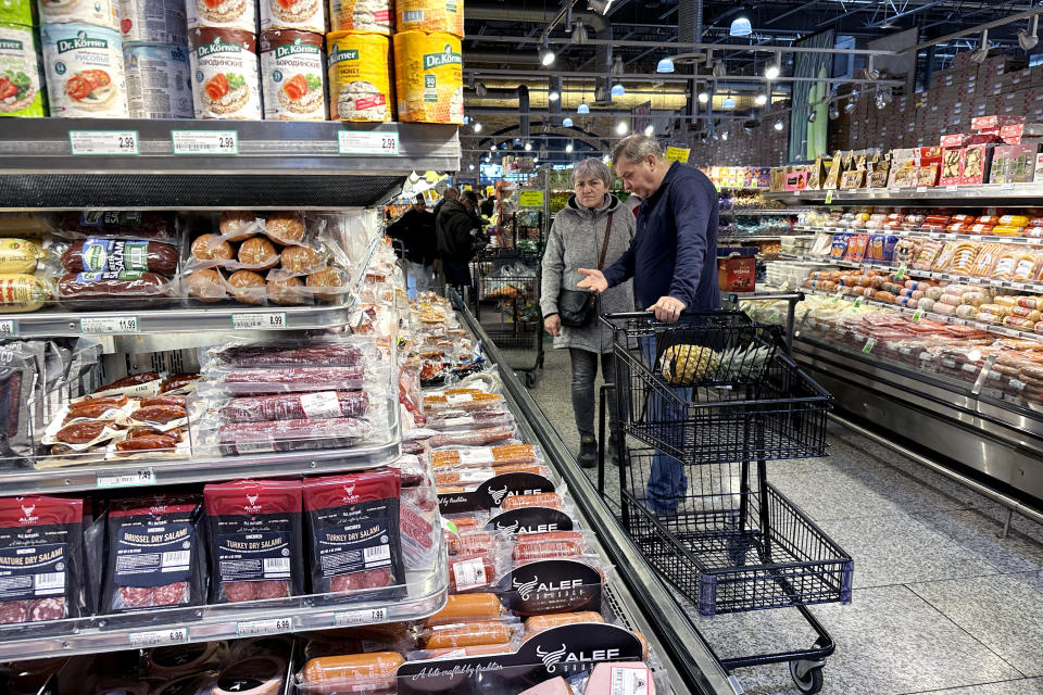 Customers check prices while shopping at a grocery store in Wheeling, Ill., Saturday, Jan. 27, 2024. (AP Photo/Nam Y. Huh)