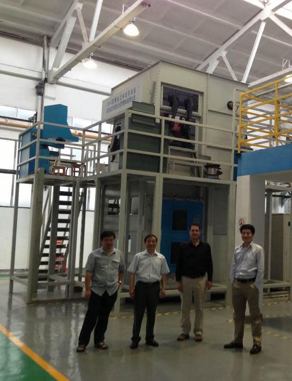 At a height of about two stories high, this may be the world's largest metal 3D printer. At Northwestern Polytechnical University (NPU) in Xi'an, professor Huang Weidong (second from left) has successfully printed precisely shaped titanium airp